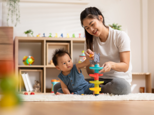 Adult and child playing with colorful toy.