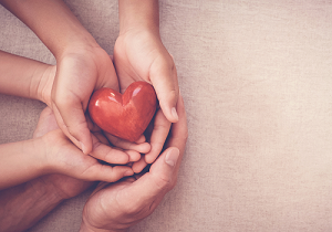 Hands holding a heart.