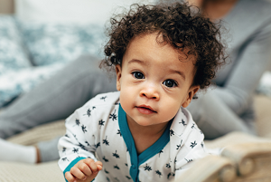 Baby boy with adorable curly brown hair.