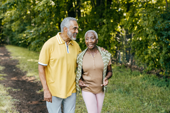 Older African American couple walking outdoors.