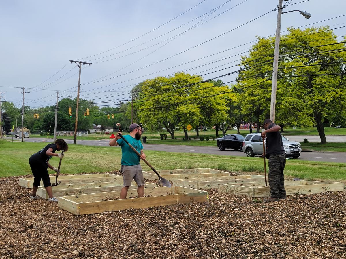 Image of people preparing ground level garden frames for use.