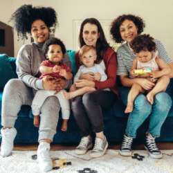 Image of 3 moms sitting on a couch with babies.